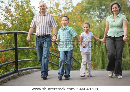Сток-фото: емья · с · двумя · детьми · гуляет · по · мосту · в · парке · ранней · осенью · Семья · на · руках