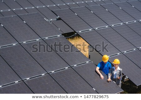 ストックフォト: Two People Standing Amid Solar Cells In A Power Plant
