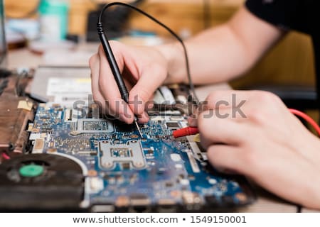 Stock fotó: Hands Of Young Master Of Gadget Repair Service Using Two Small Soldering Irons