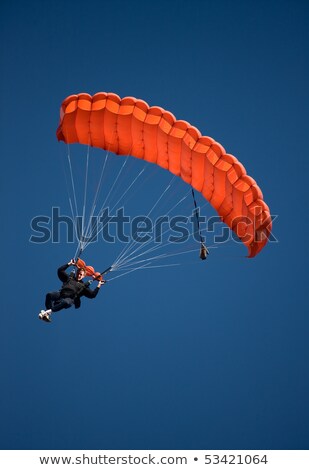Stock photo: Parachuter Descending Against Blue Sky