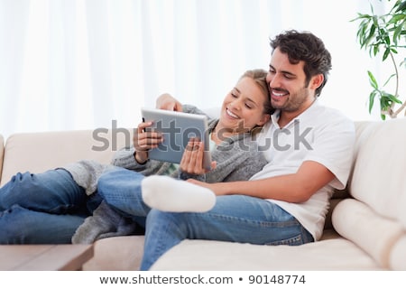 Foto d'archivio: Young Beautiful Woman Resting On A Sofa With Tablet Computer At Home