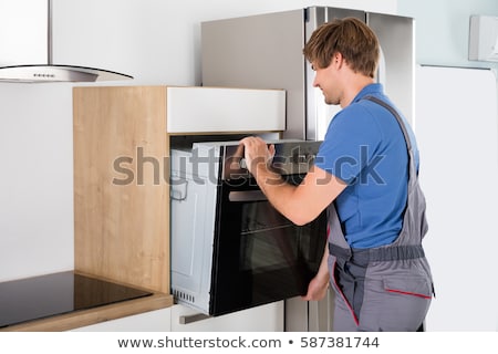 Stock foto: Technician In Overall Installing Oven