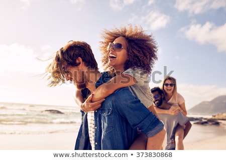 Stock photo: Mixed Race Couple Walking Along Beach With Friends