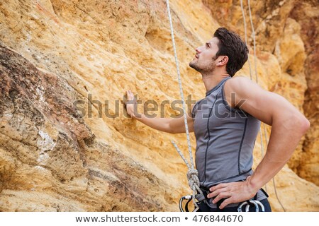 Stok fotoğraf: Young Handsome Sportsman Getting Ready To Climb A Cliff
