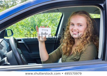 Stok fotoğraf: Young Dutch Woman Showing Card Driving License In Car