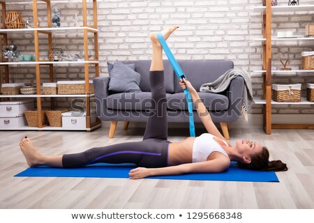 Stockfoto: Woman Using Yoga Belt While Doing Exercise