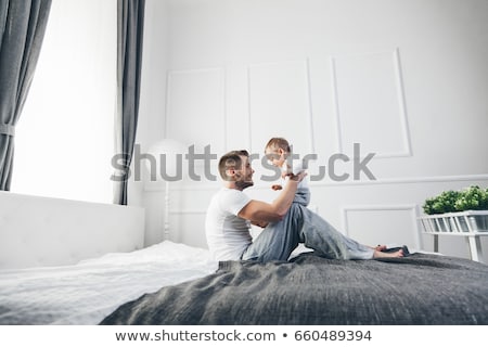 Foto d'archivio: Family On Bed With His Baby On The Morning