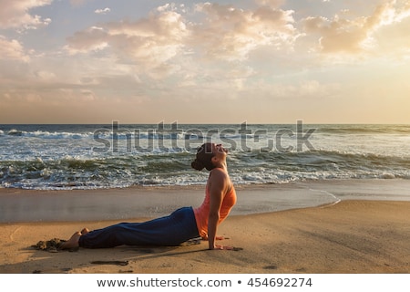 Stock photo: Woman Practices Yoga Asana Urdhva Mukha Svanasana At The Beach