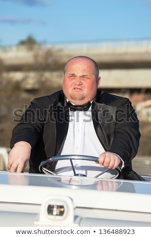Overweight Man In A Tuxedo At The Helm Of A Pleasure Boat ストックフォト © Discovod
