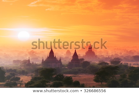 Foto stock: Amazing Sunset Colors And Silhouettes Of Ancient Buddhist Temple Myanmar