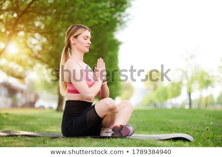 Stock photo: Woman In Zen Lotos Yoga Position On Grass