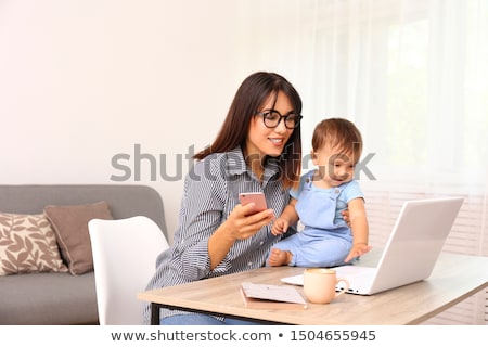 Stock fotó: Happy Mother With Baby And Laptop Working At Home