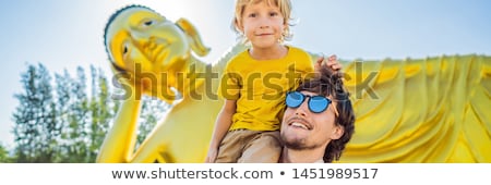 Stok fotoğraf: Happy Tourists Dad And Son On Background Oflying Buddha Statue Banner Long Format