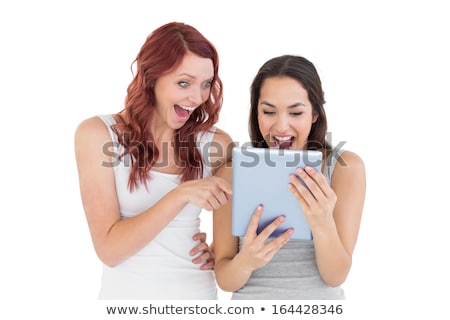 Stockfoto: Two Friends Looking Surprised At Tablet Computer Against A White