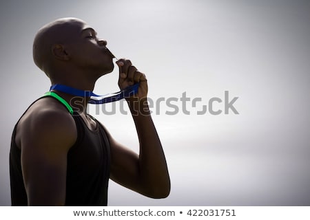 Foto d'archivio: Composite Image Of Profile View Of Athletic Man Kissing His Gold