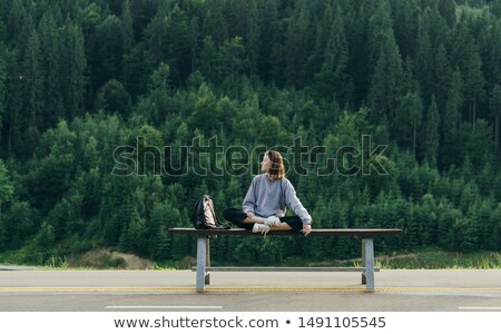 [[stock_photo]]: Caucasian Woman Sitting On Bench In Mountain Landscape