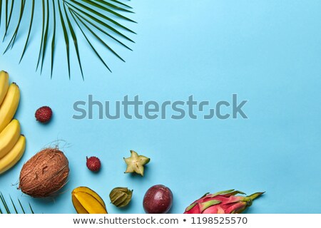 Stok fotoğraf: Summer Composition Of Ripe Sweet Exotic Fruits And Palm Branches On A Blue Background With Space For