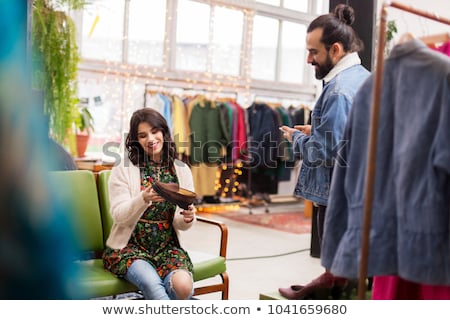 Foto stock: Couple Choosing Footwear At Vintage Clothing Store