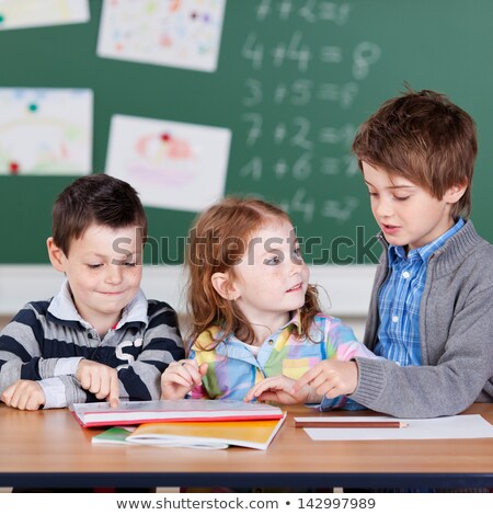 Foto stock: Three Kids Working In Group In Classroom