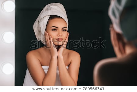 Stok fotoğraf: Smiling Young Woman Standing At The Mirror At The Bathroom