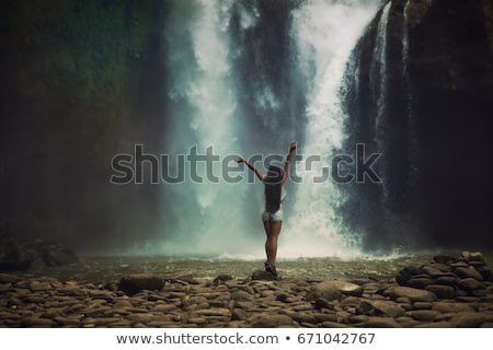 Foto stock: Woman Traveler On A Waterfall Background Ecotourism Concept