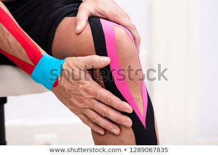 Foto stock: Man Applying Kinesiology Tape On His Knee