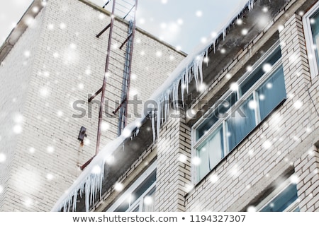 Foto stock: Icicles On Building Or Living House Facade