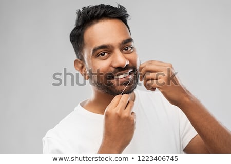ストックフォト: Indian Man With Dental Floss Cleaning Teeth