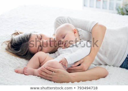 Stock foto: Parents Cuddling Newborn Baby In Bed At Home