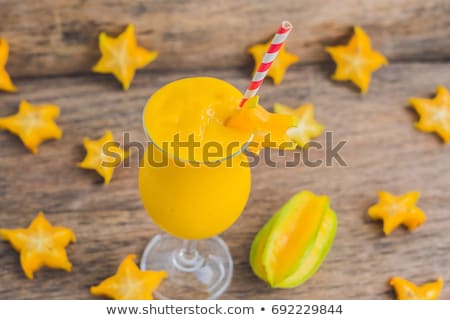 Foto d'archivio: Mango Smoothies And Pieces Of Carambola On An Old Wooden Background