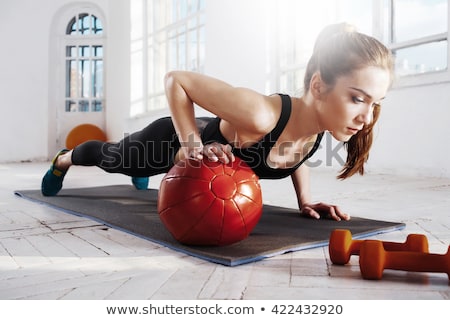 Foto stock: Beautiful Slim Brunette Doing Some Stretching Exercises In A Gym