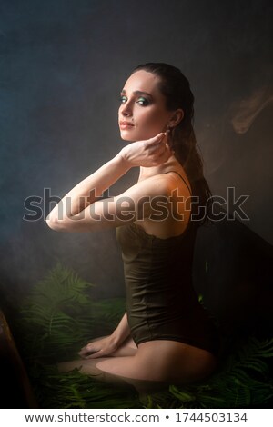 Stok fotoğraf: Portrait Of Woman In Bodysuit Exhaling Smoke On Black