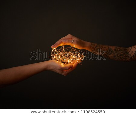 In The Hands Of A Girl With A Tattoo Of Bright Yellow Lights Around A Dark Background Stockfoto © artjazz