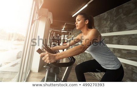 Stok fotoğraf: Smiling Woman Cycling At Gym