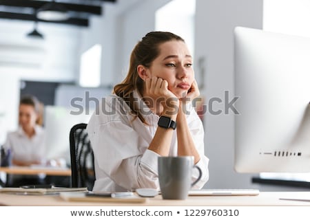 Stockfoto: Bored Young Woman Dressed In Shirt Sitting At Her Workplace