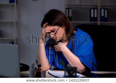 Stok fotoğraf: Aged Female Doctor Working At Night Shift