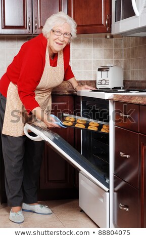 Foto stock: Senior Woman Baking Cookies On The Stove