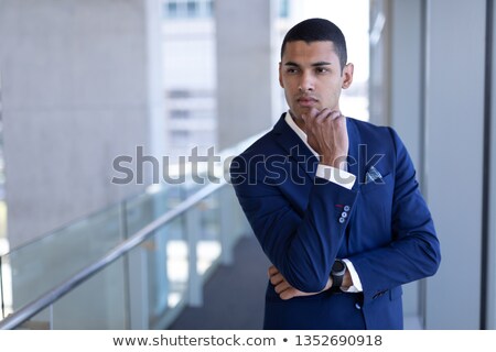 Stock fotó: Front View Of Thoughtful Young Mixed Race Businessman Looking Away Standing In Modern Office