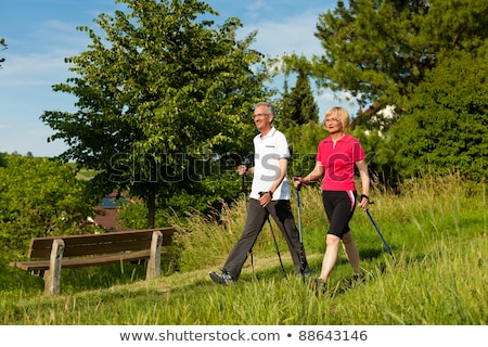 Happy Mature Or Senior Couple Doing Nordic Walking In Summer Stockfoto © Kzenon