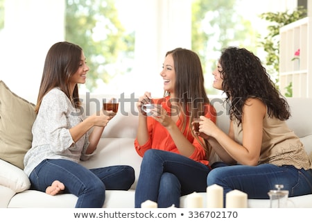 Foto stock: Happy Young Women Drinking Tea With Sweets At Home