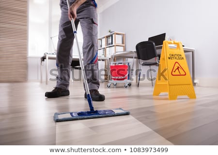 Сток-фото: Male Janitor Cleaning Floor With Mop