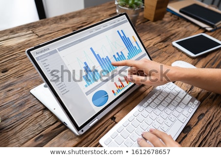 Сток-фото: Businesswoman Analyzing Graph On Laptop At Workplace