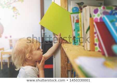 Stockfoto: Little Cute Child Picking Books From The Bookshelf