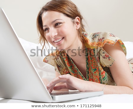 Сток-фото: Young Woman Using Her Laptop While Lying On A Couch