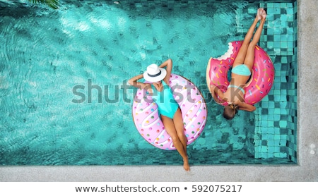Foto stock: Two Girls Relaxing By The Pool