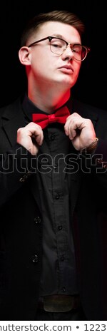 Zdjęcia stock: Portrait Of Confident Handsome Elegant Responsible Businessman Correcting Bow Tie On Black Backgroun