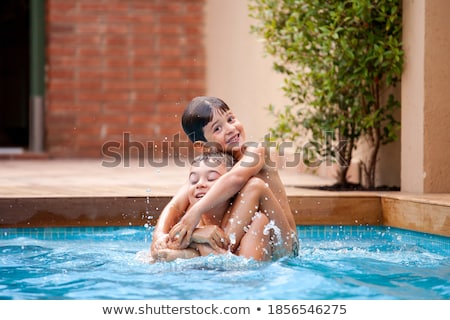 Stok fotoğraf: Happy Young Family Having Fun Inside A Swimming Pool