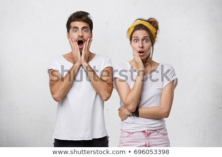 Stok fotoğraf: Portrait Of A Shocked Young Couple Standing Together