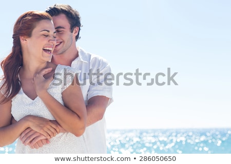 Foto d'archivio: Portrait Of A Lovely Young Couple Hugging At The Beach