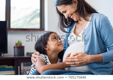 Foto stock: Pregnant Mother And Daughter Hugging At Home
